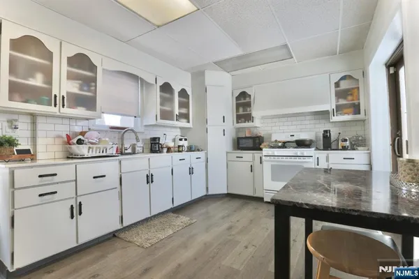 a kitchen with granite countertop white cabinets and white appliances