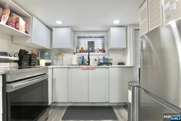 a kitchen with white cabinets and white appliances