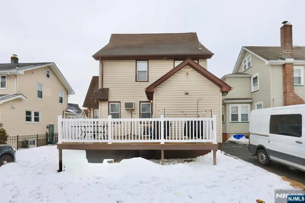 a view of a house with a deck and a yard