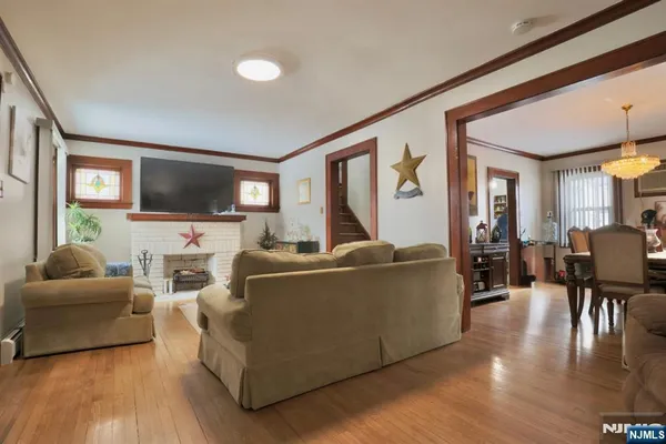 a living room with furniture a flat screen tv and wooden floor