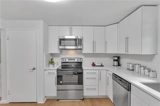 a kitchen with stainless steel appliances a sink stove and cabinets