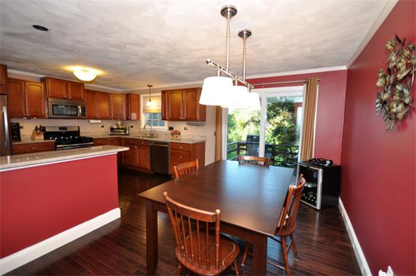 6 Apple Ridge Road, Unit 1 Maynard, MA 01754 - Photo 3 of 14 a kitchen with stainless steel appliances granite countertop a stove a refrigerator a kitchen island a sink dishwasher a dining table and chairs with wooden floor