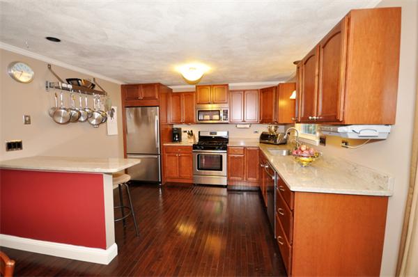 6 Apple Ridge Road, Unit 1 Maynard, MA 01754 - Photo 4 of 14 a kitchen with stainless steel appliances a stove a refrigerator a sink and white cabinets with wooden floor