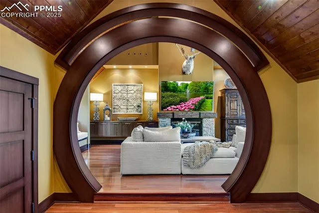 a living room with a floor to ceiling window and potted plants