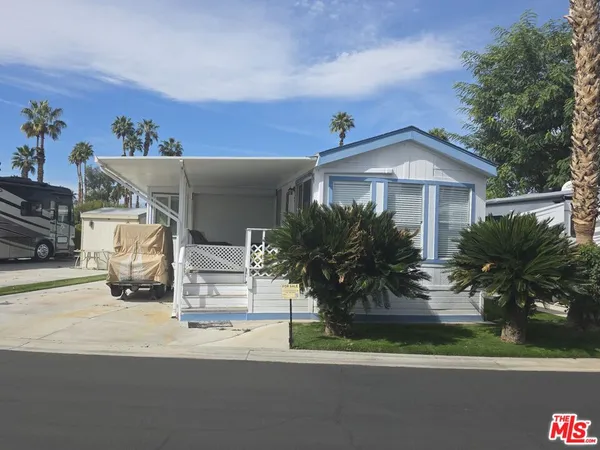 a front view of a house with a yard and potted plants