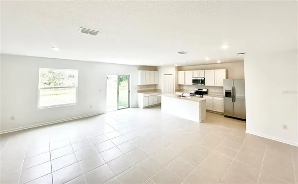 a large white kitchen with cabinets and a refrigerator