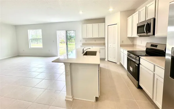a kitchen with granite countertop a stove a sink and a microwave