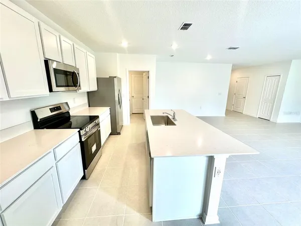 a kitchen with stainless steel appliances a microwave a sink and a refrigerator