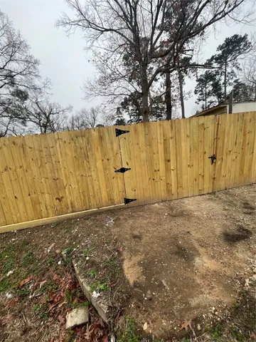 a view of backyard with wooden fence
