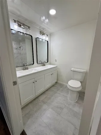 a spacious bathroom with a toilet sink and mirror