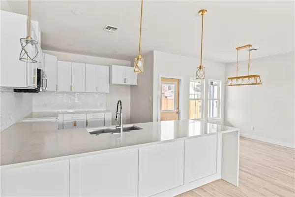 a kitchen with stainless steel appliances granite countertop a sink a counter space and cabinets