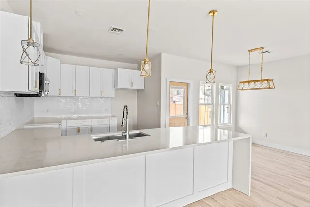 a kitchen with stainless steel appliances granite countertop a sink a counter space and cabinets