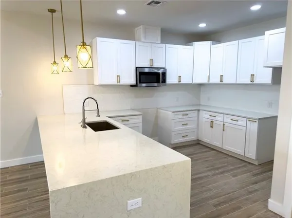 a kitchen with kitchen island a sink a stove and cabinets