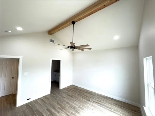 a view of a room with wooden floor and a window