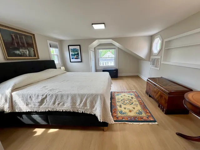 a spacious bedroom with a bed and a lamp on table