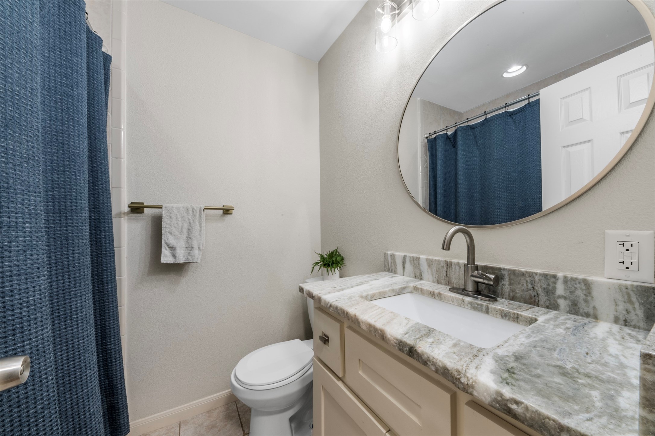 1913 Thonig Road Houston, TX 77055 - Photo 18 of 36 a bathroom with a granite countertop sink a toilet and a mirror