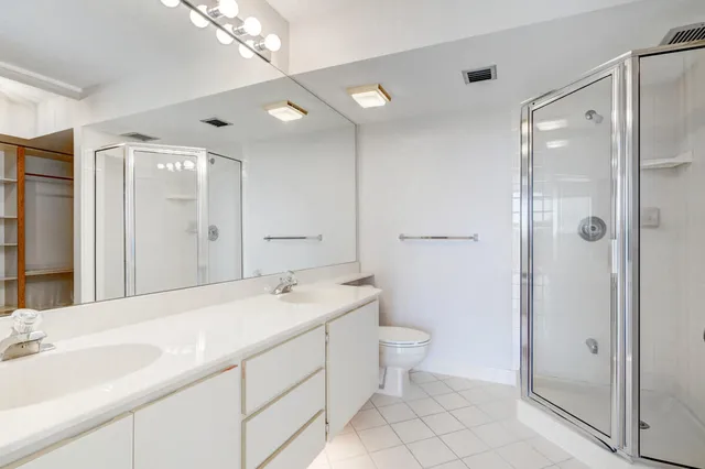 a spacious bathroom with a shower sink mirror and toilet