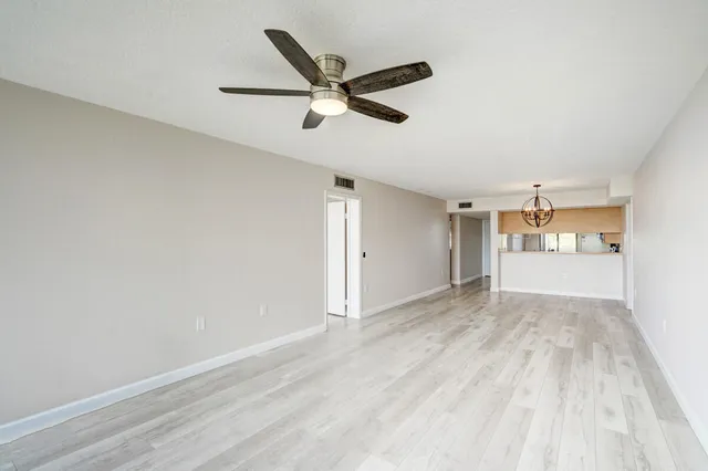a view of a livingroom with a ceiling fan & hardwood floor