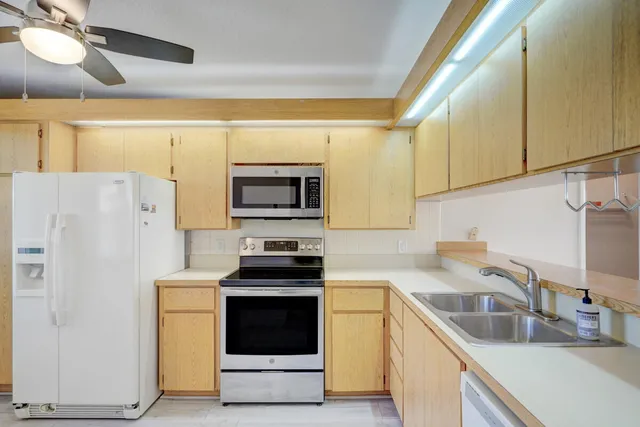 a kitchen with stainless steel appliances a stove a sink and a refrigerator