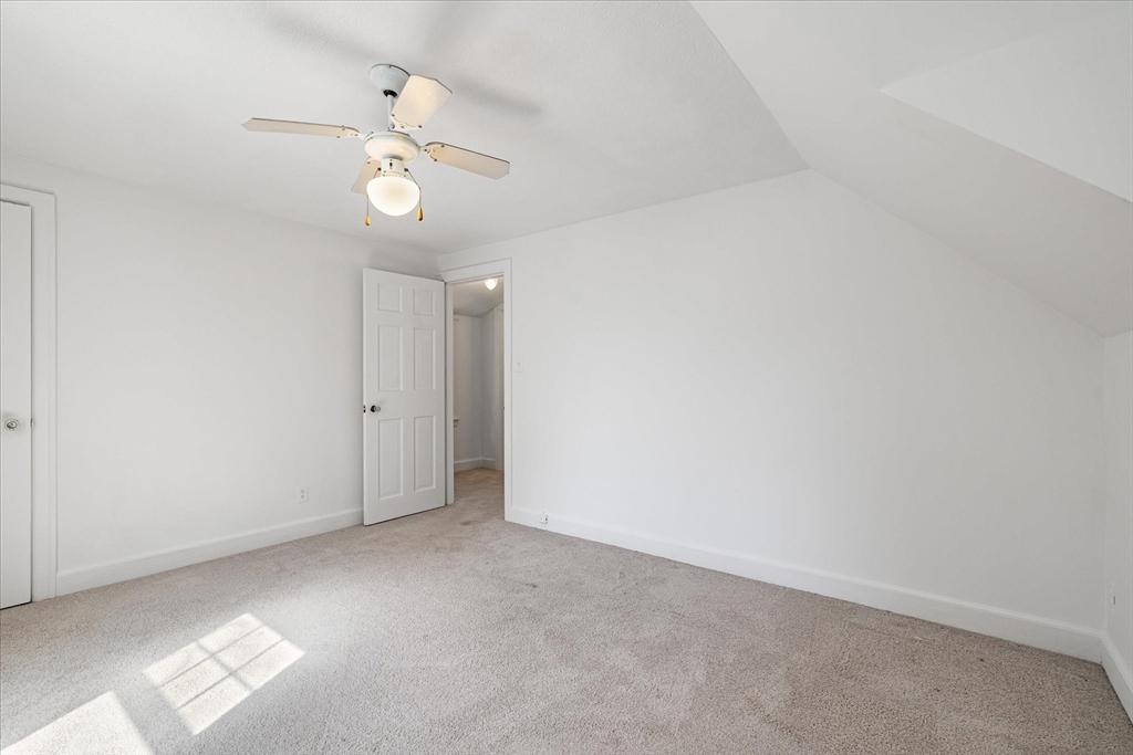 54 Ellsworth Avenue Springfield, MA 01118 - Photo 22 of 29 an empty room with a chandelier fan and windows