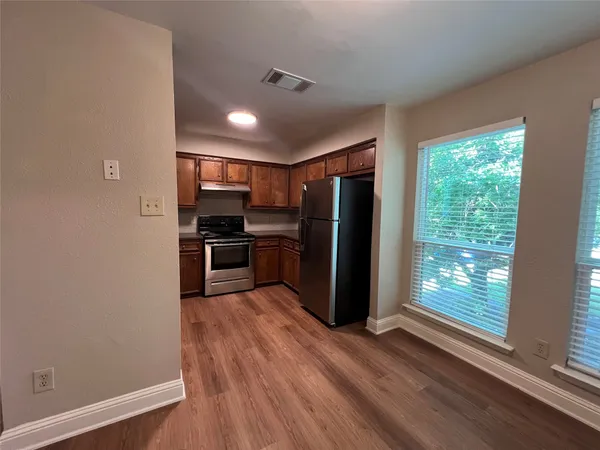 a view of kitchen with wooden floor electronic appliances and window