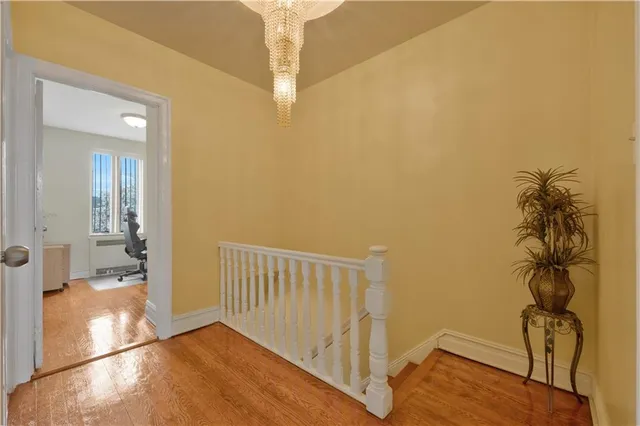 a view of hallway with bathroom and wooden floor