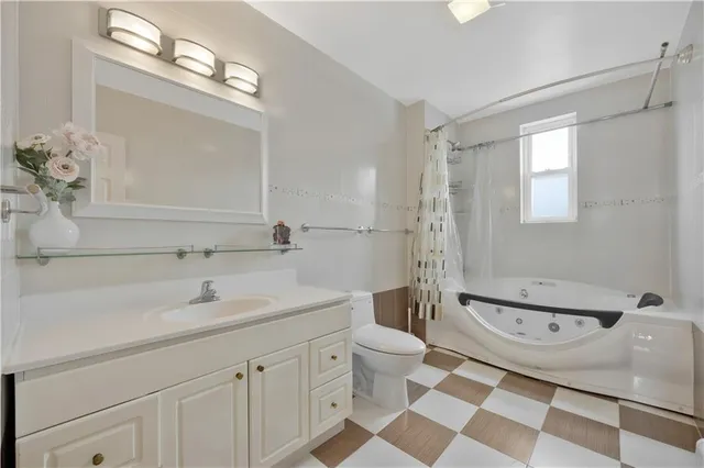 a spacious bathroom with a bathtub shower sink mirror and toilet
