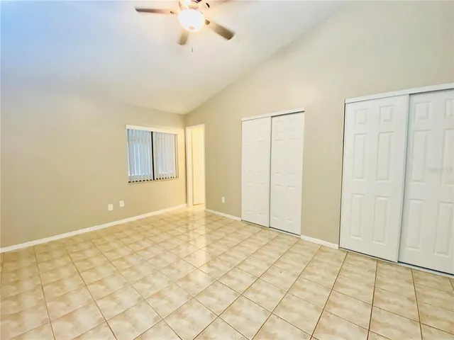 a view of an empty room and chandelier fan