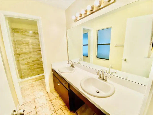 a bathroom with a double vanity sink and a mirror