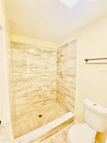 a bathroom with a toilet and a shower