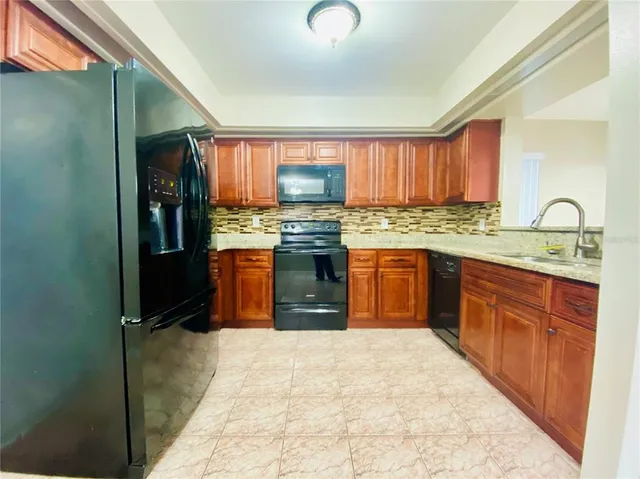a kitchen with granite countertop a stove top oven sink and cabinets