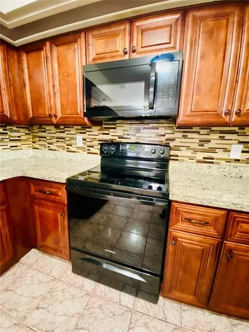 a kitchen with stainless steel appliances granite countertop a stove and a microwave