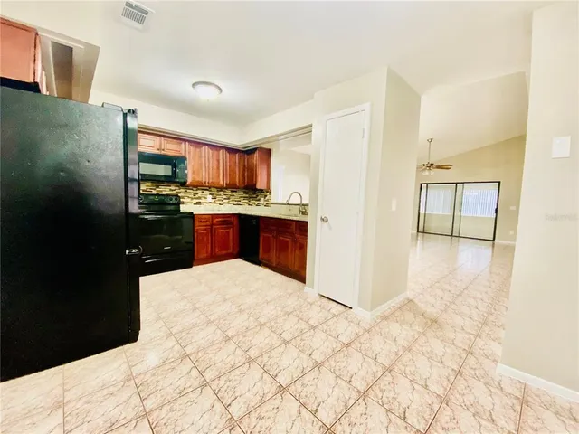 a kitchen with stainless steel appliances kitchen island granite countertop a refrigerator and a sink