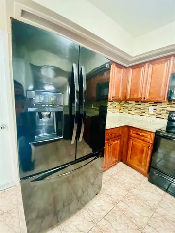 a kitchen with stainless steel appliances granite countertop a refrigerator a stove and a sink