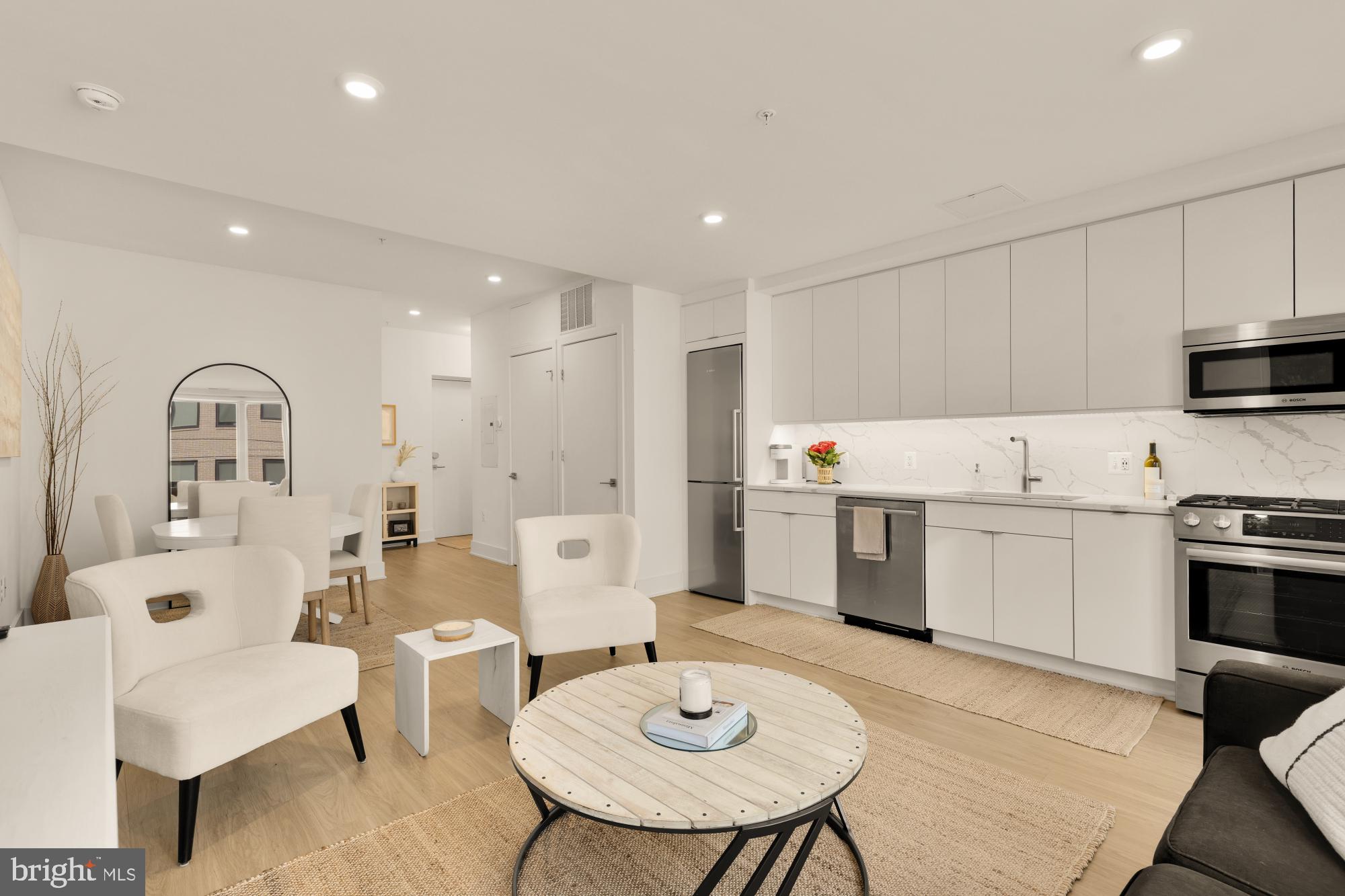 1761 P Street Northwest, Unit 202 Washington, DC 20036 - Photo 5 of 17 a kitchen with stainless steel appliances a white table and chairs