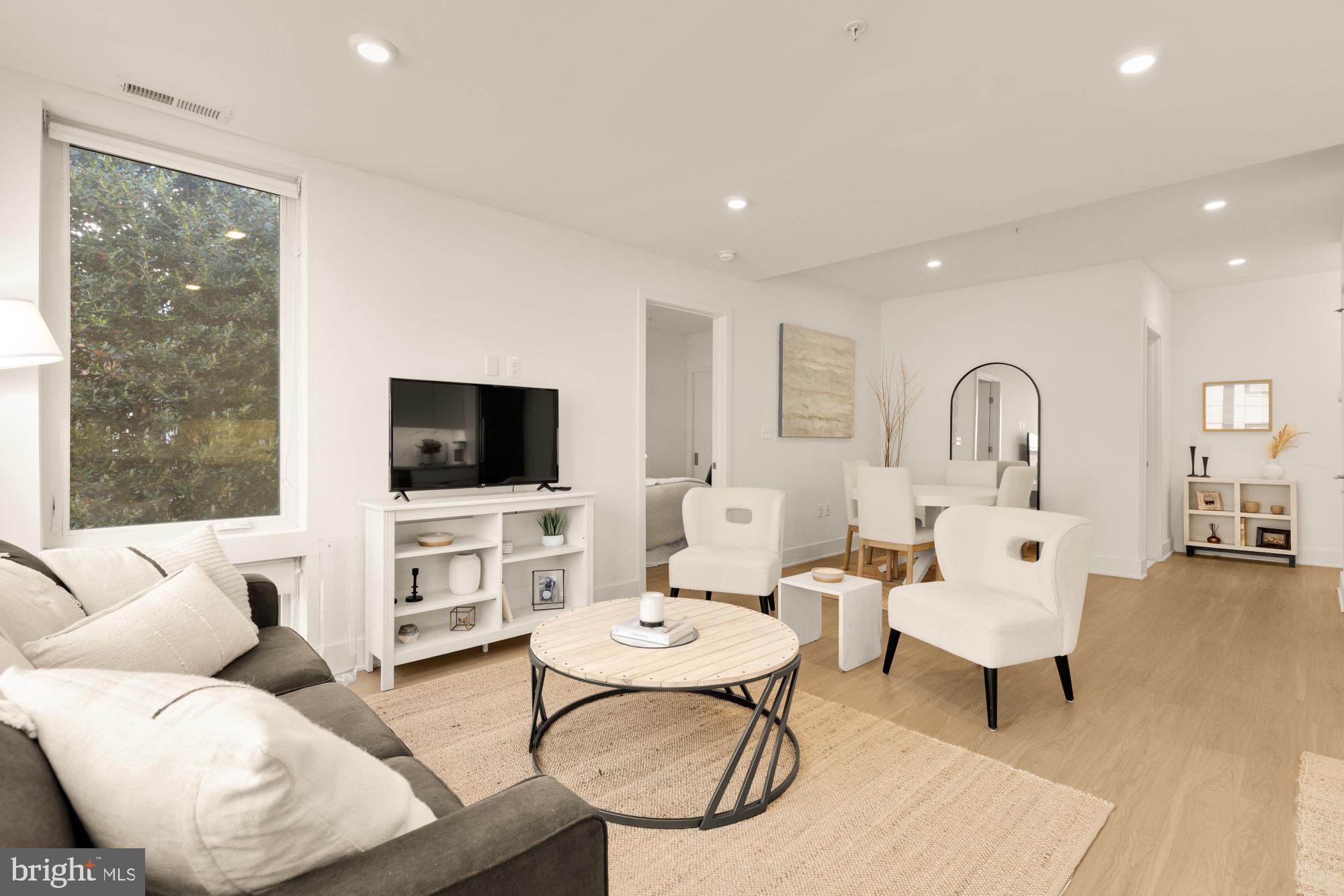 1761 P Street Northwest, Unit 202 Washington, DC 20036 - Photo 7 of 17 a living room with furniture a flat screen tv and a large window