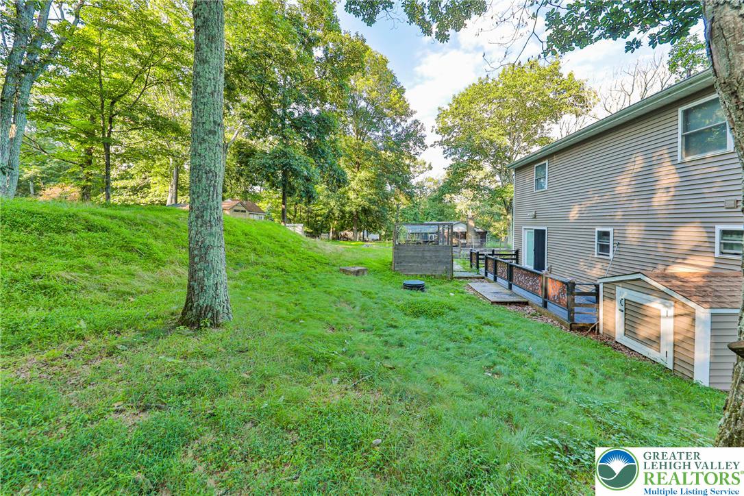 2114 Lakeview Road Bushkill, PA 18324 - Photo 62 of 83 Mature trees frame the sloping green yard and rear wood deck of this home.