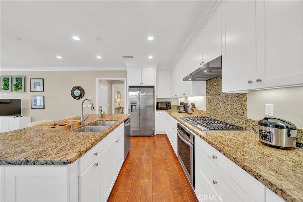 75 Gardenstone Path Irvine, CA 92620 - Photo 24 of 65 a large kitchen with granite countertop a lot of counter space and wooden floor
