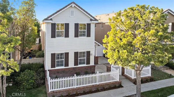 a front view of a house with a tree