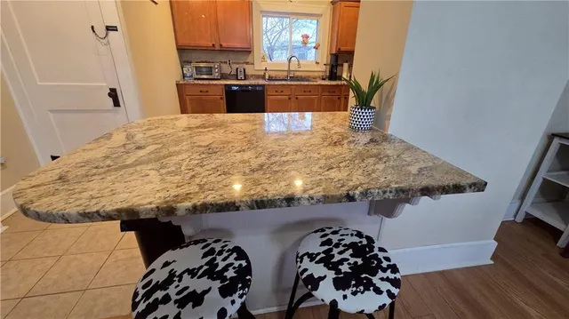 a kitchen with kitchen island a counter top space stainless steel appliances and wooden floor
