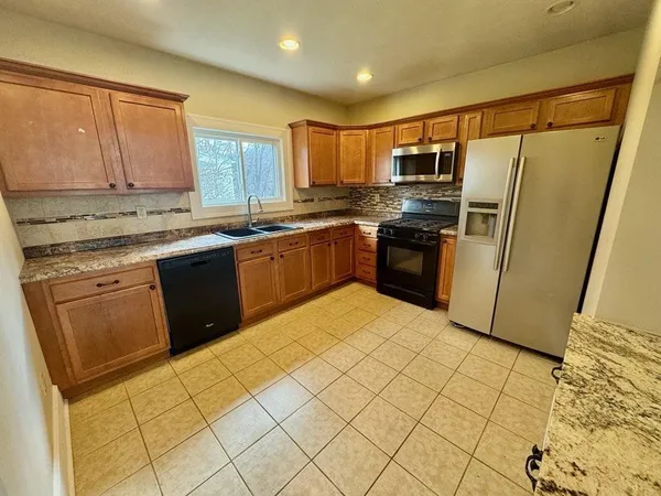 a kitchen with stainless steel appliances granite countertop a refrigerator and a sink