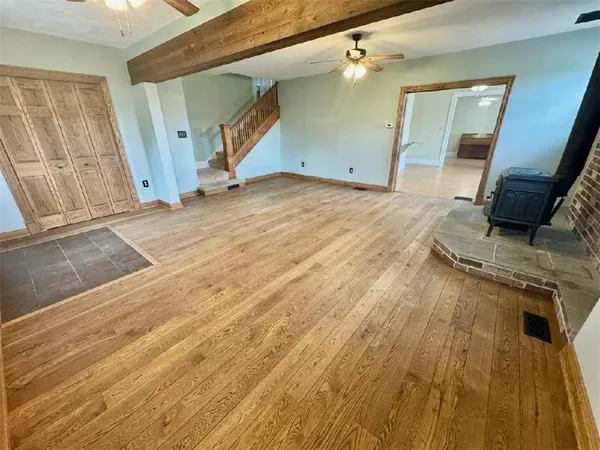 a view of a livingroom with wooden floor and staircase