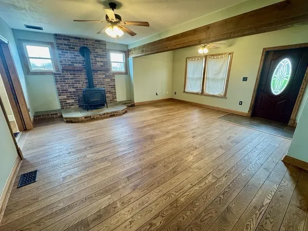 a view of a livingroom with wooden floor and a ceiling fan