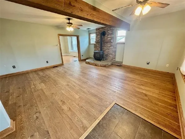 a view of a room with wooden floor and ceiling fan