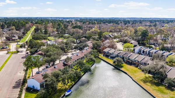 an aerial view of residential houses with outdoor space and swimming pool