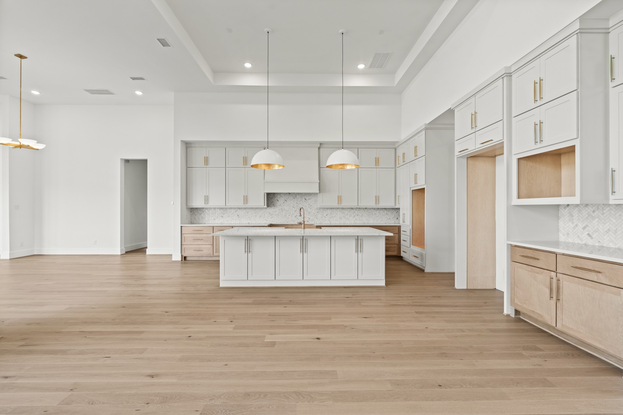 4210 Westgate Lane Fulshear, TX 77441 - Photo 29 of 48 a large white kitchen with kitchen island a sink a center island and stainless steel appliances