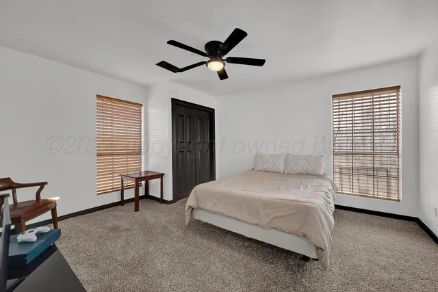 a bedroom with a bed and a ceiling fan