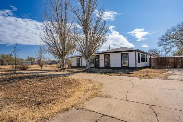 a front view of a house with a yard covered with snow