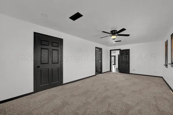 a view of an empty room with a ceiling fan