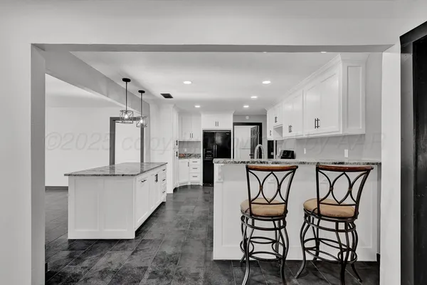 a kitchen with a table chairs refrigerator and microwave